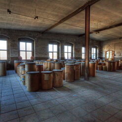 Lagerraum mit vielen Holzfässern und Fenstern.